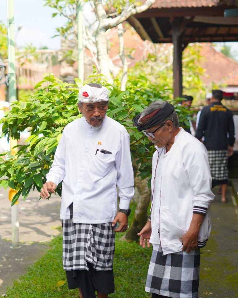 Putu Gangga sharing a conversation with a Balinese community leader at a temple.